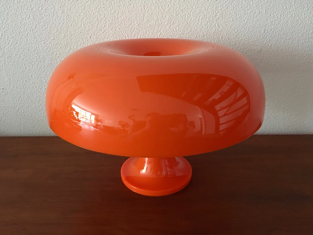 Orange Artemide Nessino bordlampe slukket på et træbord